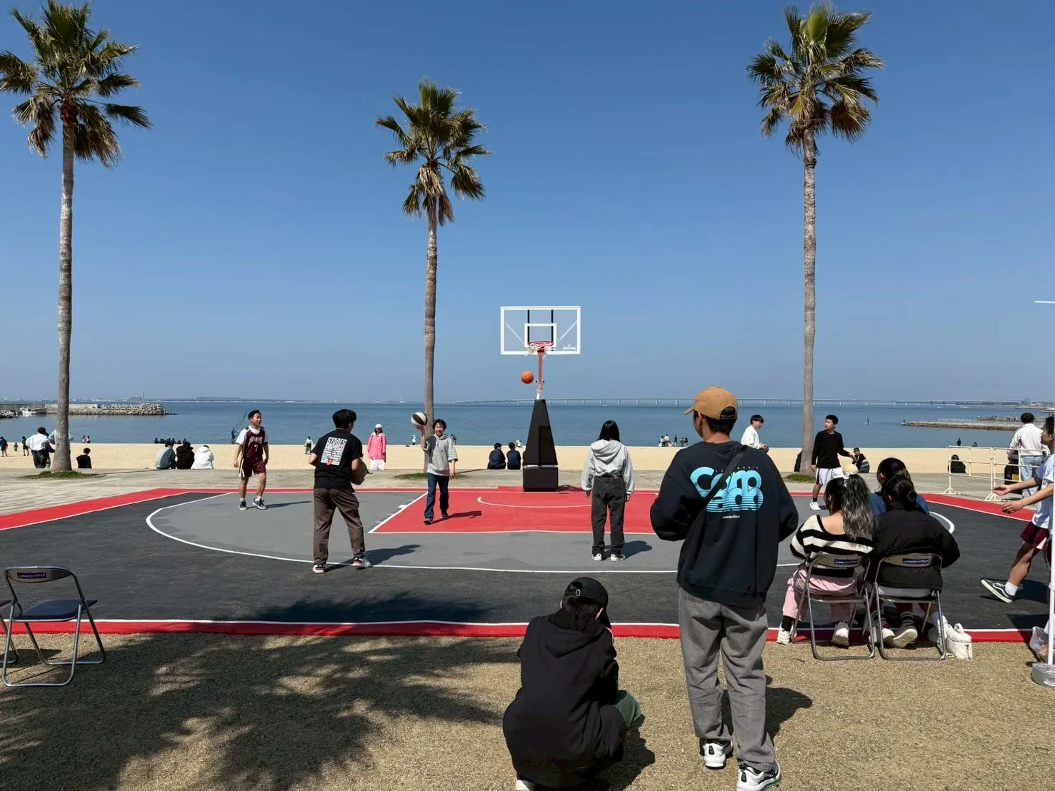 海辺の ANOTHERCOURT で行われる 3×3 試合と観戦者